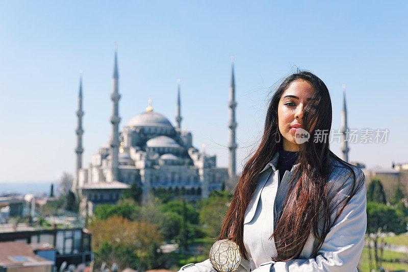 美丽的女人与蓝色清真寺的肖像，苏丹艾哈迈德区，伊斯坦布尔，土耳其