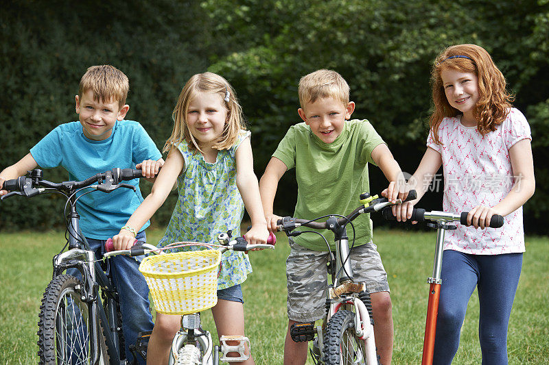 一群孩子在骑自行车和踏板车玩