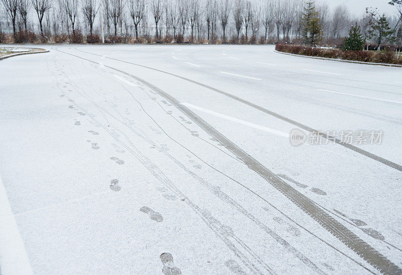 雪地上的轮胎痕迹和脚印