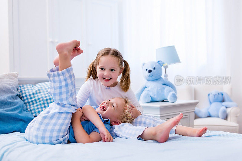 快乐的孩子们在白色的卧室里玩耍