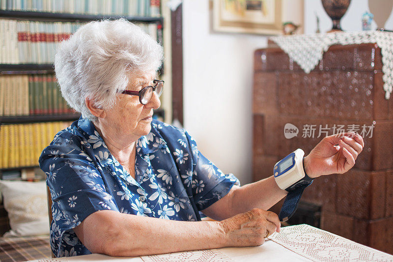 老年妇女在家测量血压。