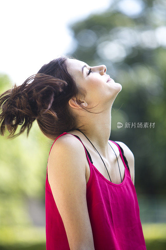 年轻女子在户外闭着眼睛放松