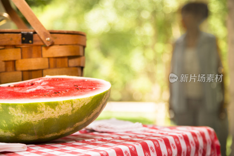 在户外野餐桌上切西瓜。夏天。篮子里。