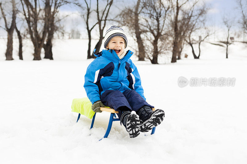 小男孩在雪地上拉雪橇