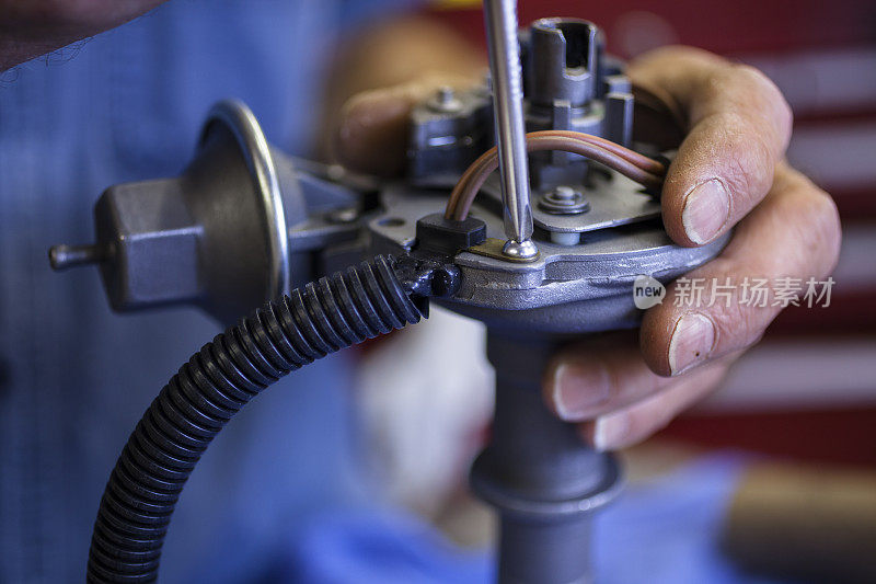 服务行业:机械师在修理厂从事点火分配器的工作。