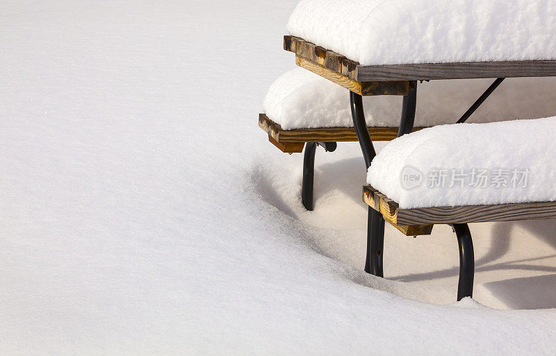 暴风雪过后，厚厚的冬雪盖过了野餐桌