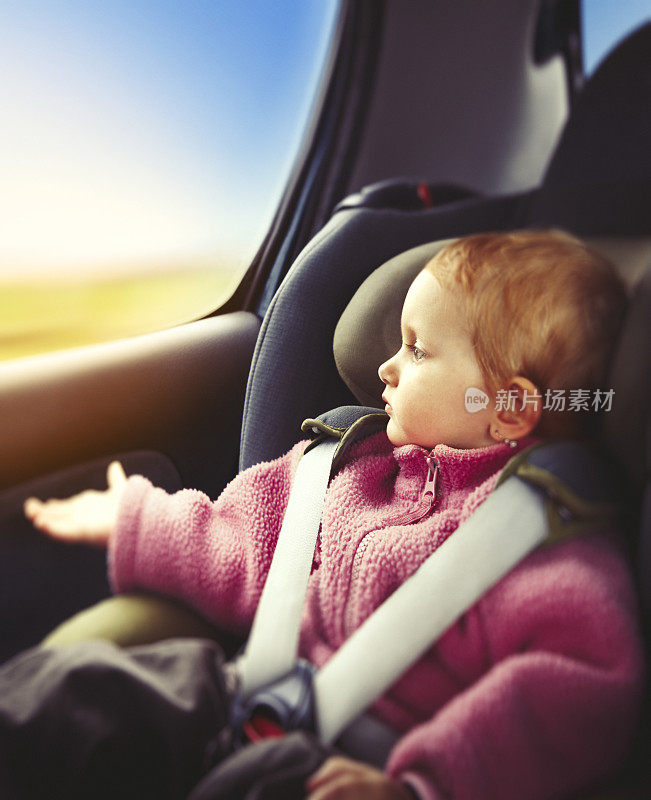 小女孩开车时坐在儿童座椅上