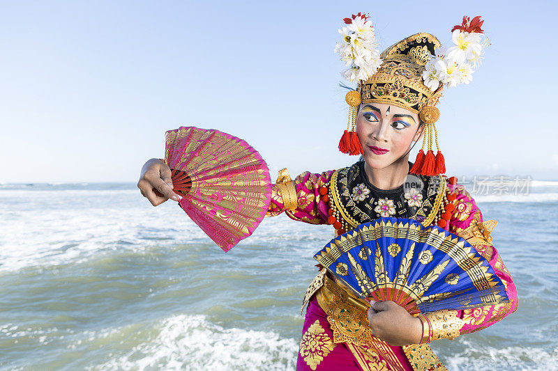 巴厘岛女舞者在传统服装与球迷在海滩上
