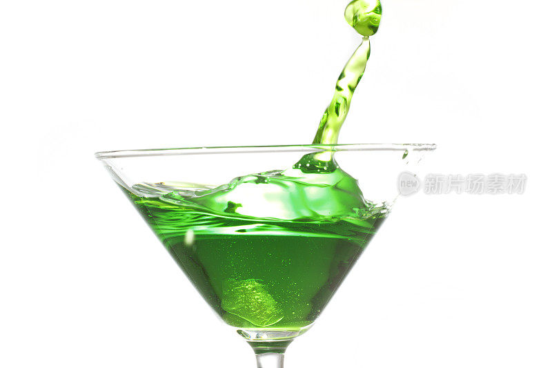 一滴绿色饮料溅入鸡尾酒杯