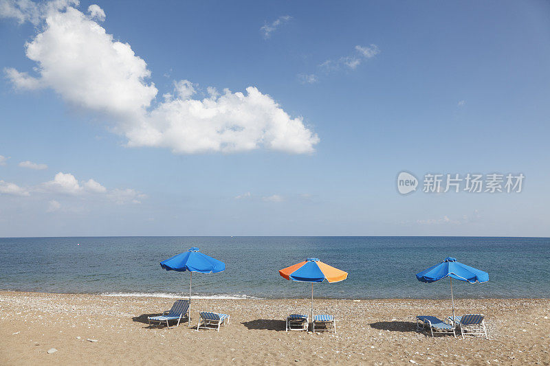 三排条纹日光浴床和雨伞塞浦路斯拉特西海滩