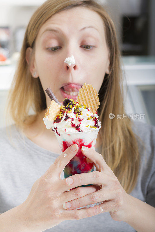 年轻女子品尝着一杯冰淇淋