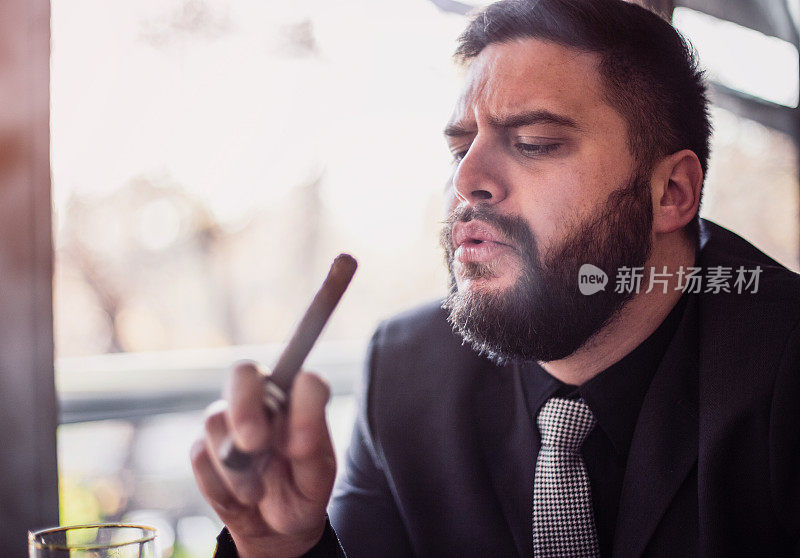 一个蓄着胡须的白人男子抽着雪茄的特写镜头