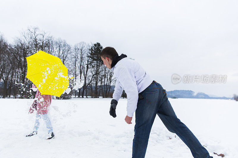 年轻人向他的女朋友扔雪球