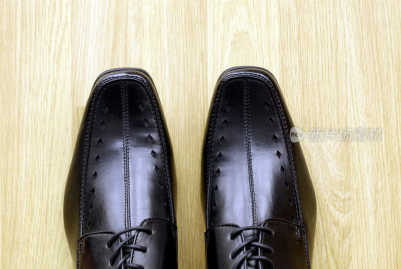 男人的黑色鞋子在木制的复合地板上