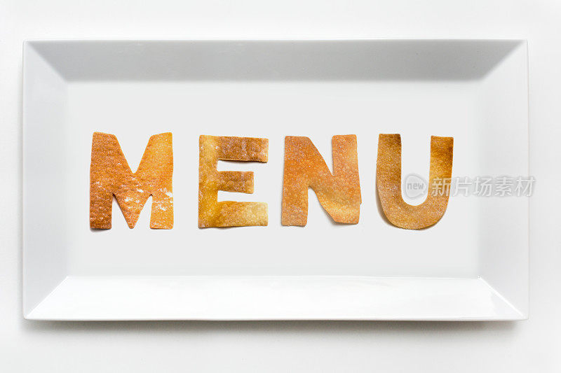 菜单上的糕点字母在白瓷长方形盘子