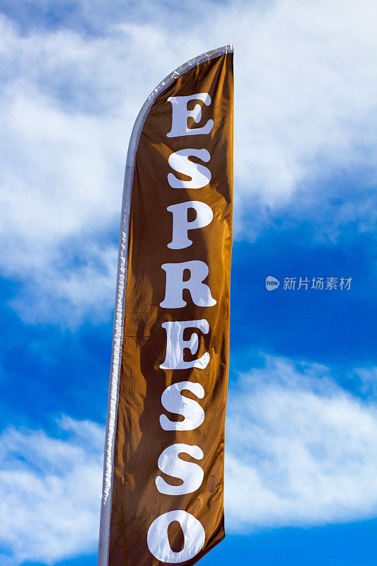 阳光下的“ESPRESSO”旗帜对抗蓝色多云的天空