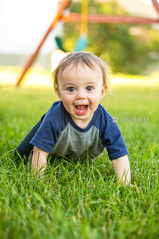小男孩在草地上爬
