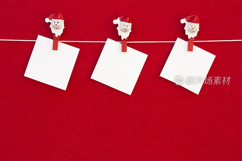 红色背景上挂着挂着晾衣绳的圣诞空白字条