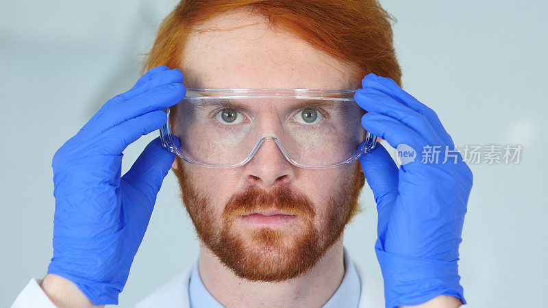 红发研究科学家的特写，戴着防护眼镜的医生