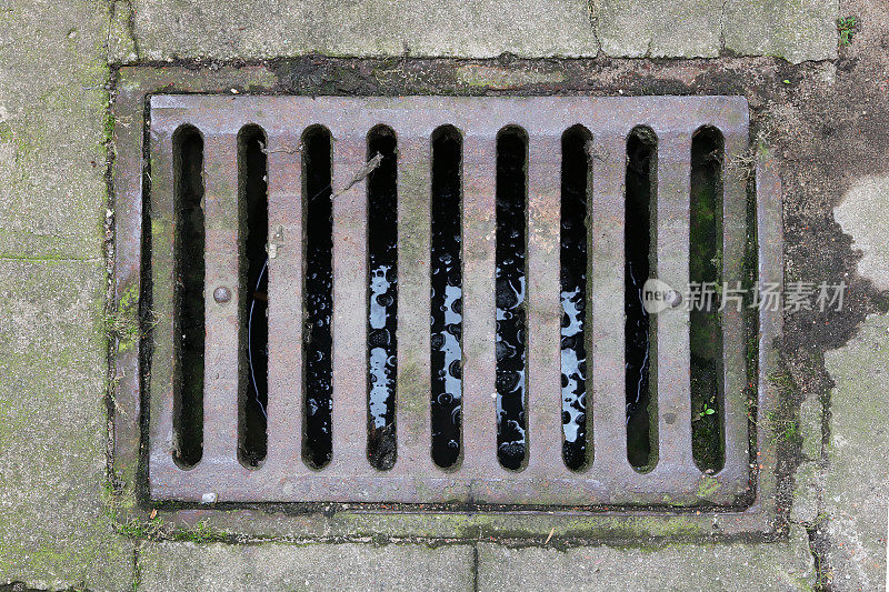 城市雨水下水道系统的生锈的旧铁制格栅。