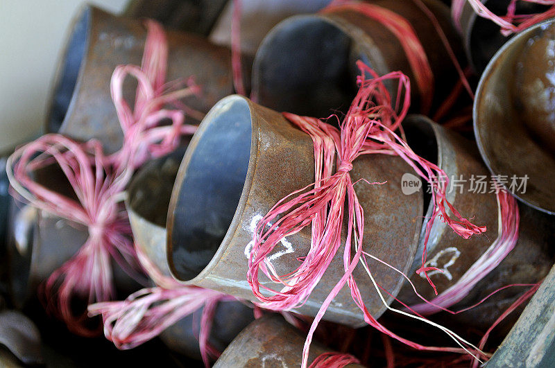 锈迹斑斑的铁罐，用粉红色的麻绳包着