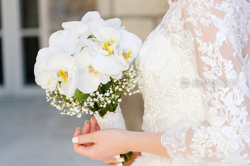 一个新娘拿着婚礼花束的特写