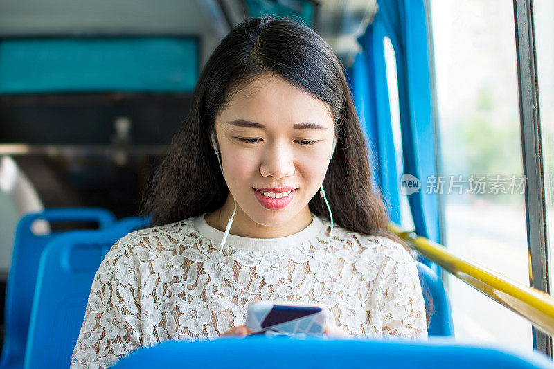在公共汽车上听音乐的女孩