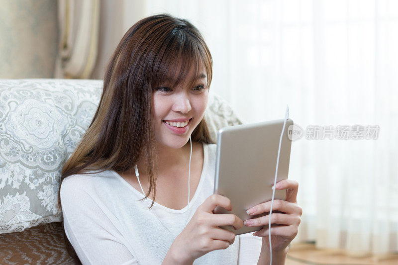 年轻美丽的亚洲女人与数字平板电脑