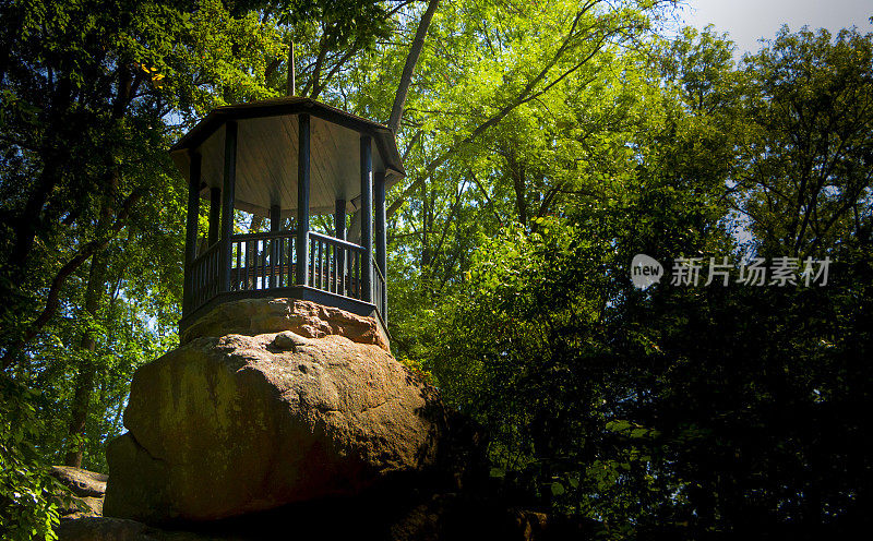 美丽的古色古香的凉亭，坐落在森林中的一块巨石上