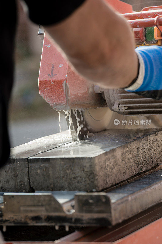 工人使用角磨床切割混凝土块在一个后视图