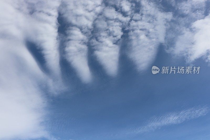 蓝色天空映衬着蓬松、缕缕白云的特写