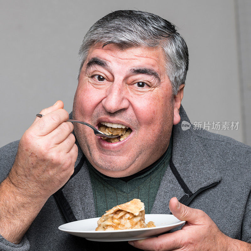 一个胖子正在吃苹果派