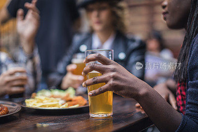 酒吧里拿着啤酒杯的黑人妇女