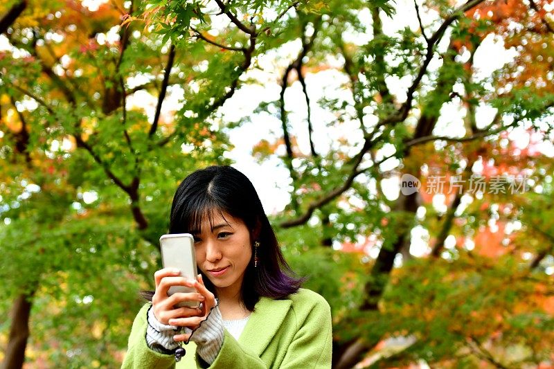 一名日本女子在东京的秋叶下自拍