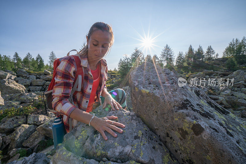 女攀登者攀登山顶;湖景