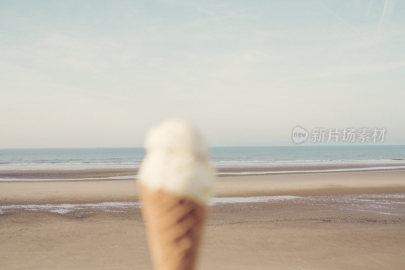 在一个阳光明媚的日子里，布莱克浦海滩上的无焦点冰淇淋蛋卷。