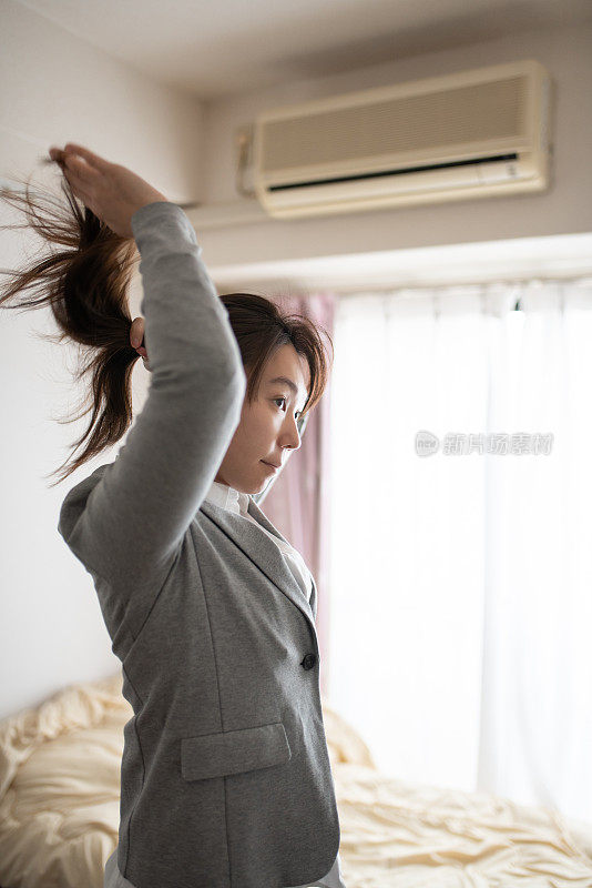 在房间里扎头发的女人