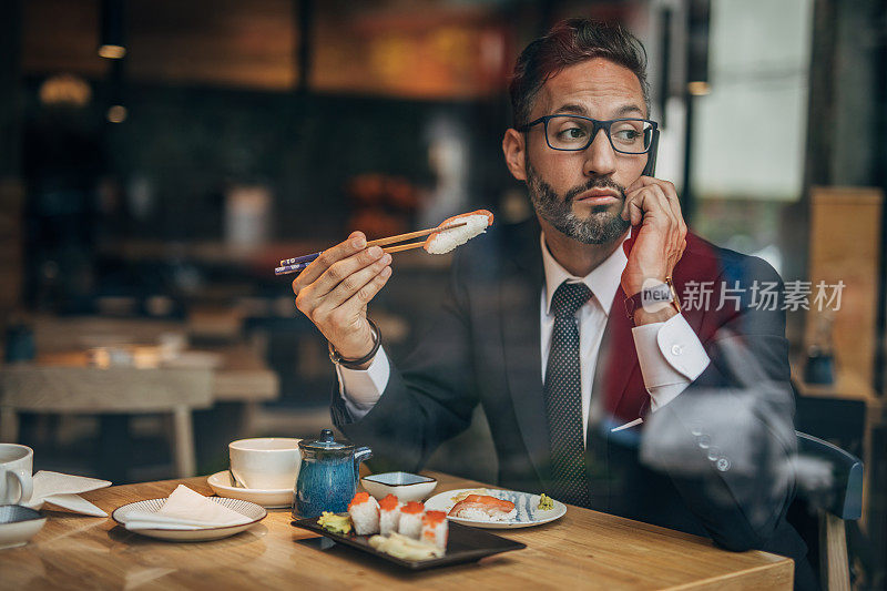 在寿司店打电话的男人