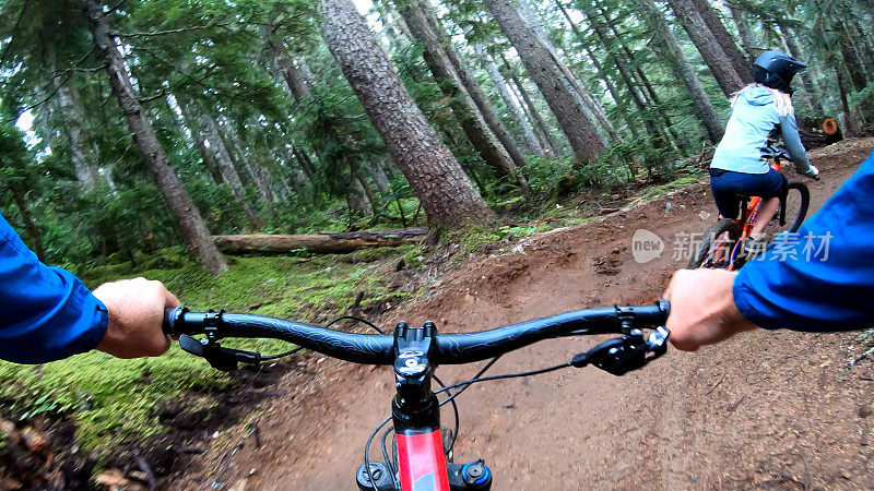 山地自行车手沿着泥泞的小路穿过森林