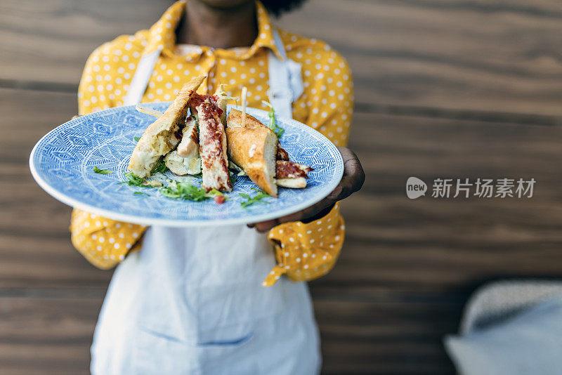 女服务员端着一盘食物