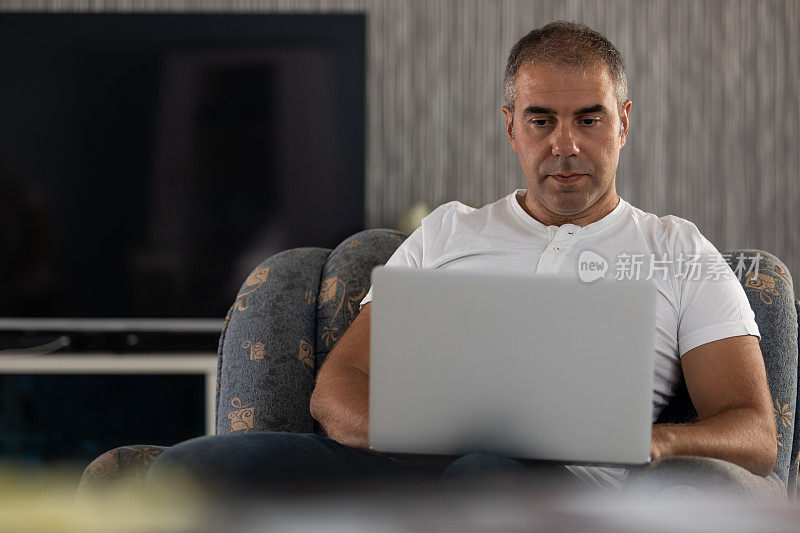 男人在家里用笔记本电脑