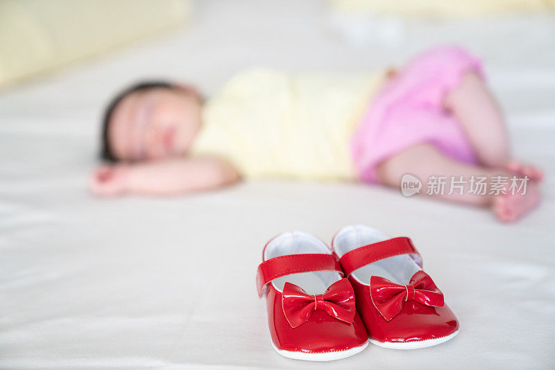 刚出生的女婴在睡觉，而她的第一双鞋就在她身边