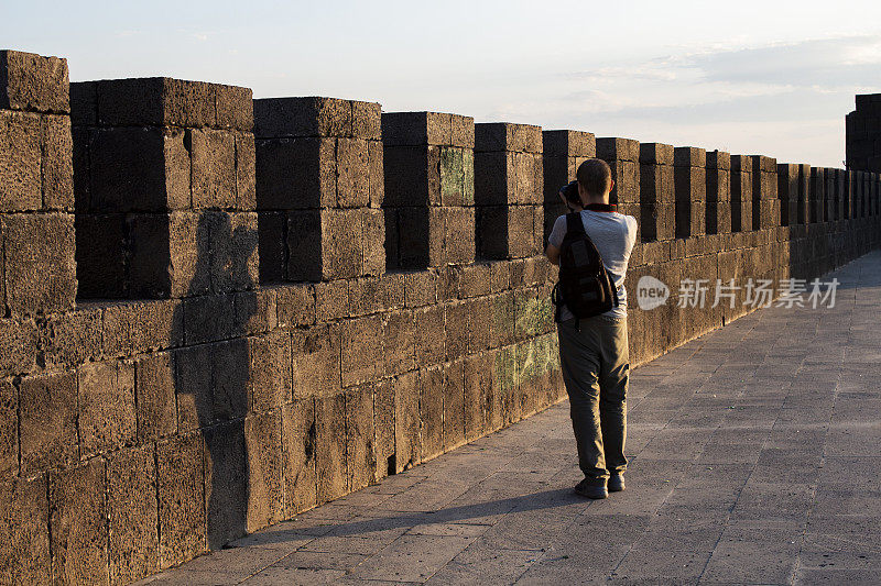 摄影师游客漫步迪亚巴克尔的墙壁