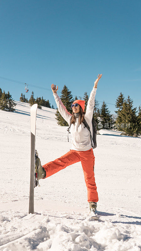 在雪中举起手臂的女子滑雪运动员