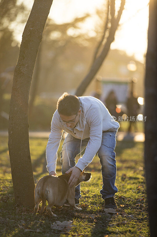 一个年轻人和他的狗在公园里