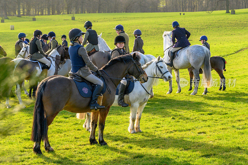 在英国乡间，孩子们骑着马，等待着猎狐活动的开始