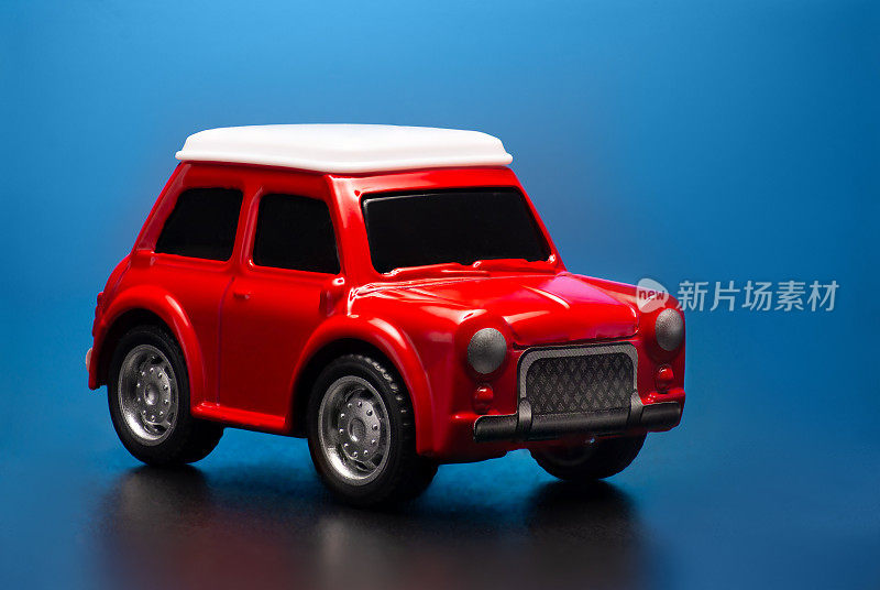 红色的小玩具汽车模型在一个蓝色的背景。