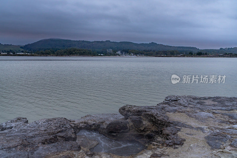 黎明时分，新西兰罗托鲁瓦湖岸边的热泥浆池