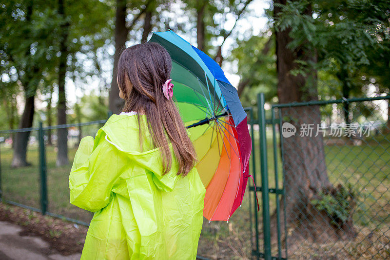 漂亮凉爽的女人带着五颜六色的雨伞在秋天的一天