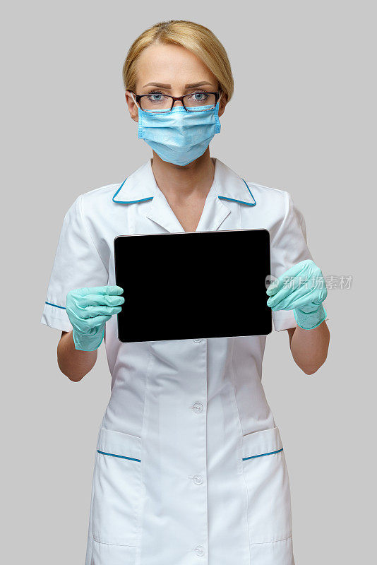 医生护士女人戴着防护口罩和手套拿着平板电脑